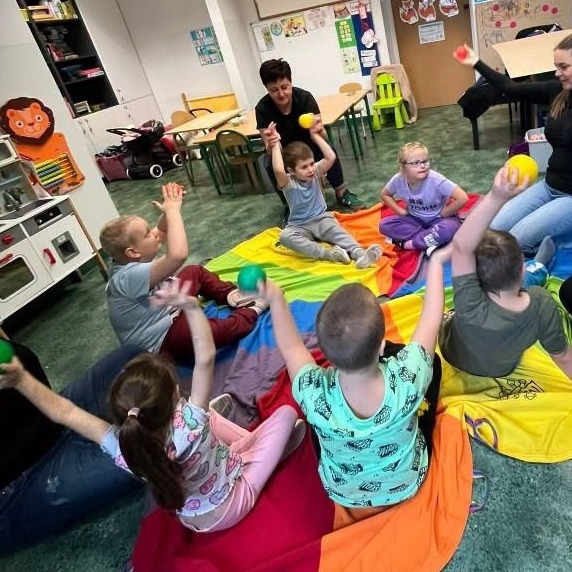 Zabawa z chustą animacyjną i kolorowymi piłeczkami