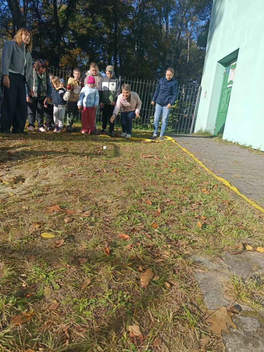Uczniowie i nauczycielki podczas gry w bocce na szkolnym boisku