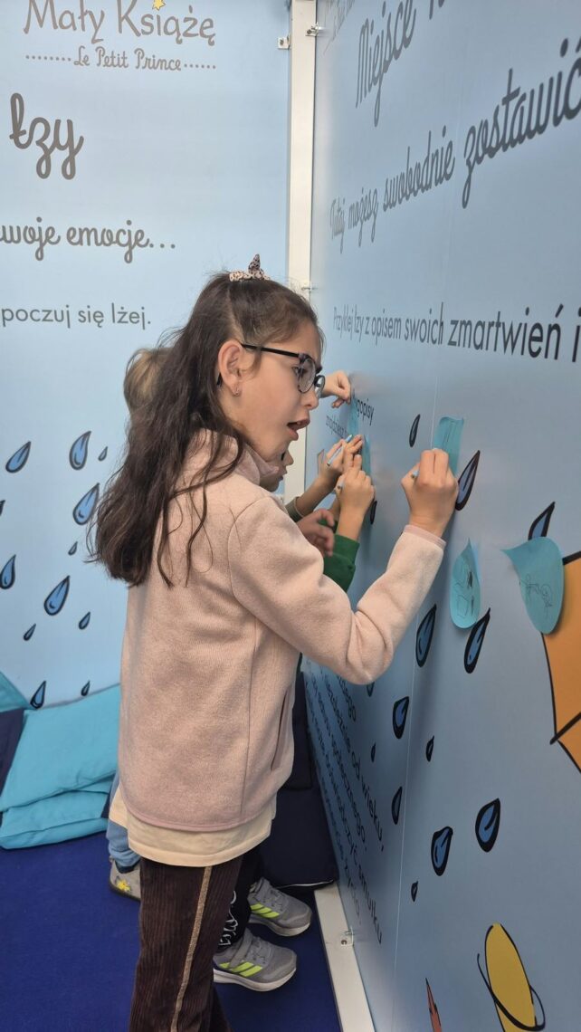Uczennica przykleja łzę z opisem zmartwienia