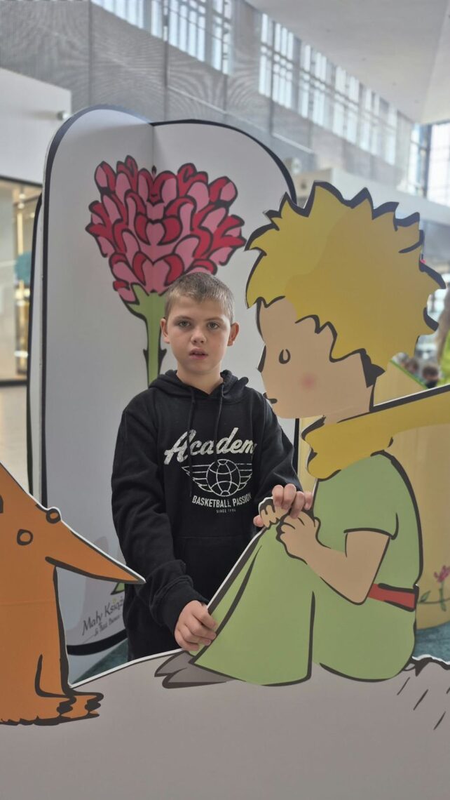 Uczeń przy dekoracji z Małym Księciem