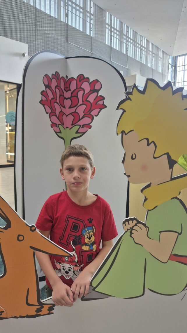 Uczeń pozuje przy postaci Małego Księcia