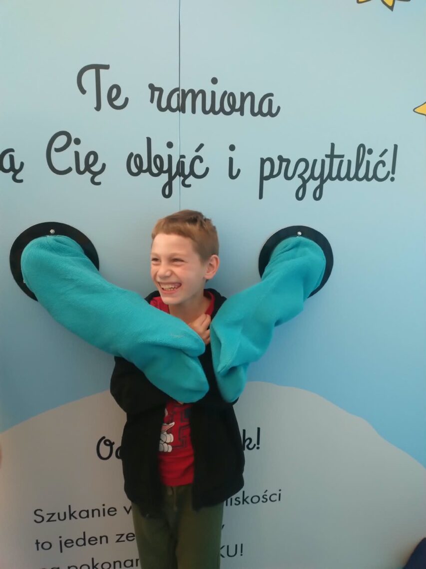 Uczeń przy instalacji „Te ramiona mogą Cię objąć i przytulić”