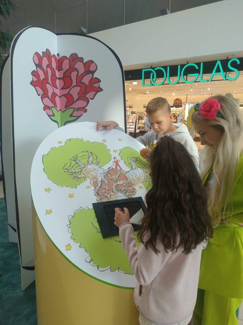 Uczniowie z prowadzącą przy kolorowance z różą