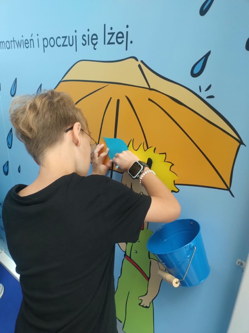 Uczeń przy ścianie z parasolem w strefie smutku