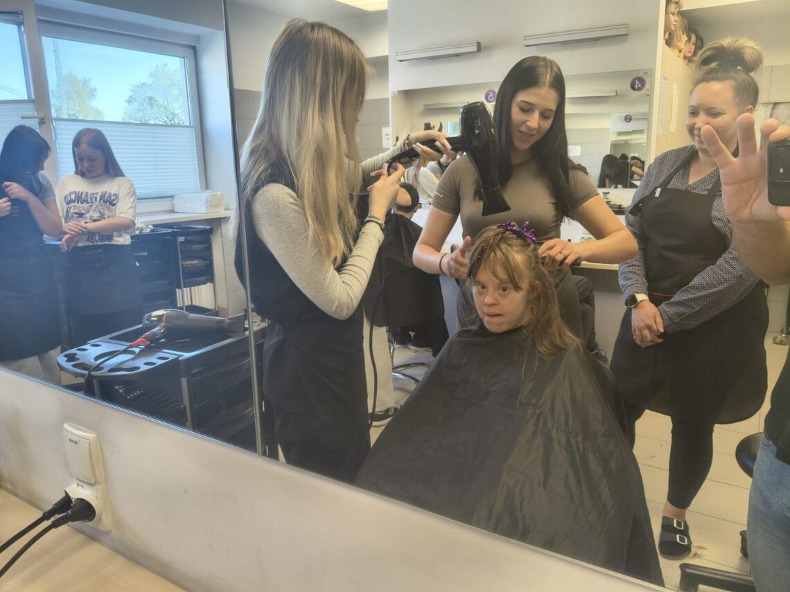 Układanie fryzury uczennicy, widok w lustrze salonu