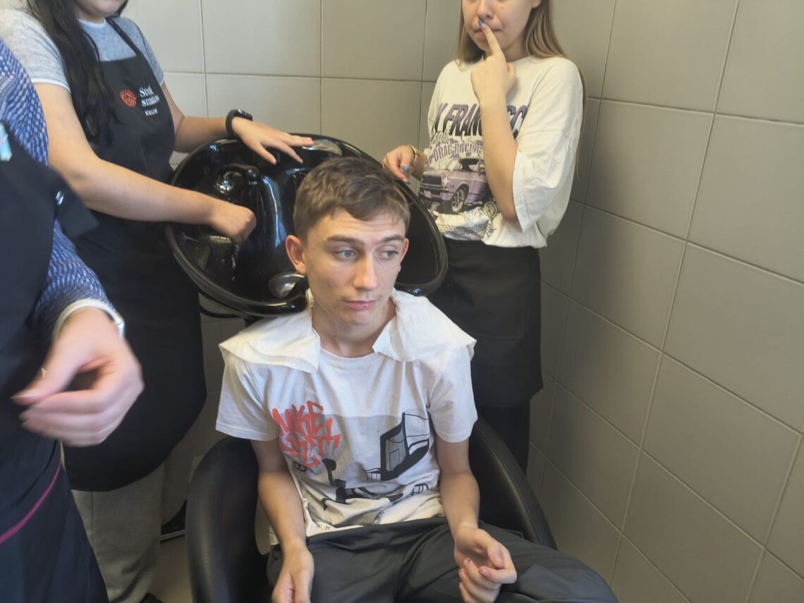 Uczeń przy myjni fryzjerskiej przed myciem głowy